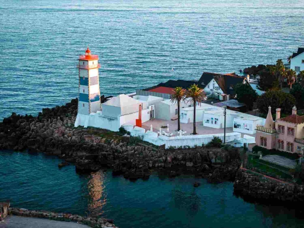 Striped lighthouse overlooking the Atlantic Ocean in Cascais Portugal