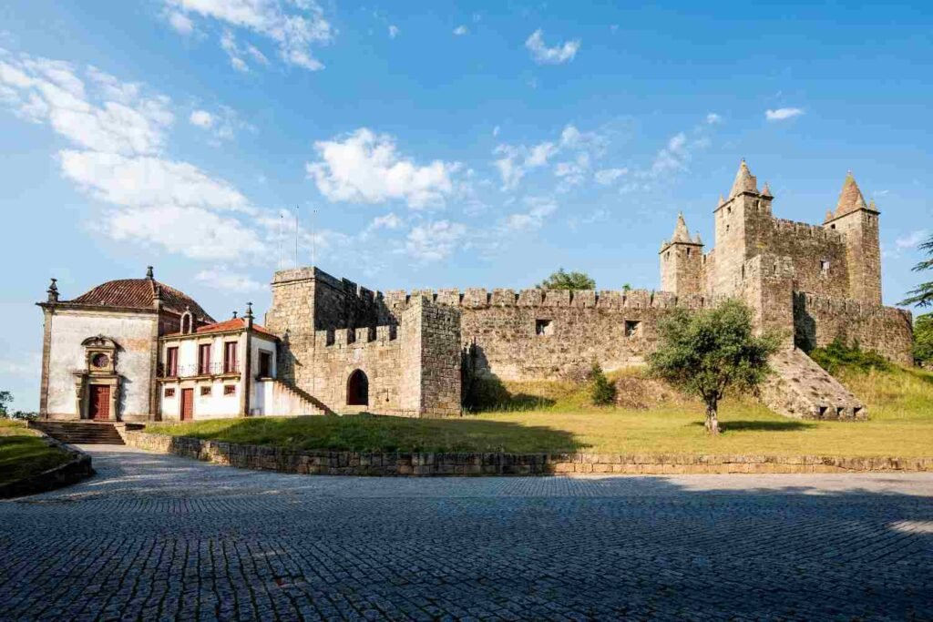 Historic stone castle and buildings in a Portuguese village beneath a blue sky