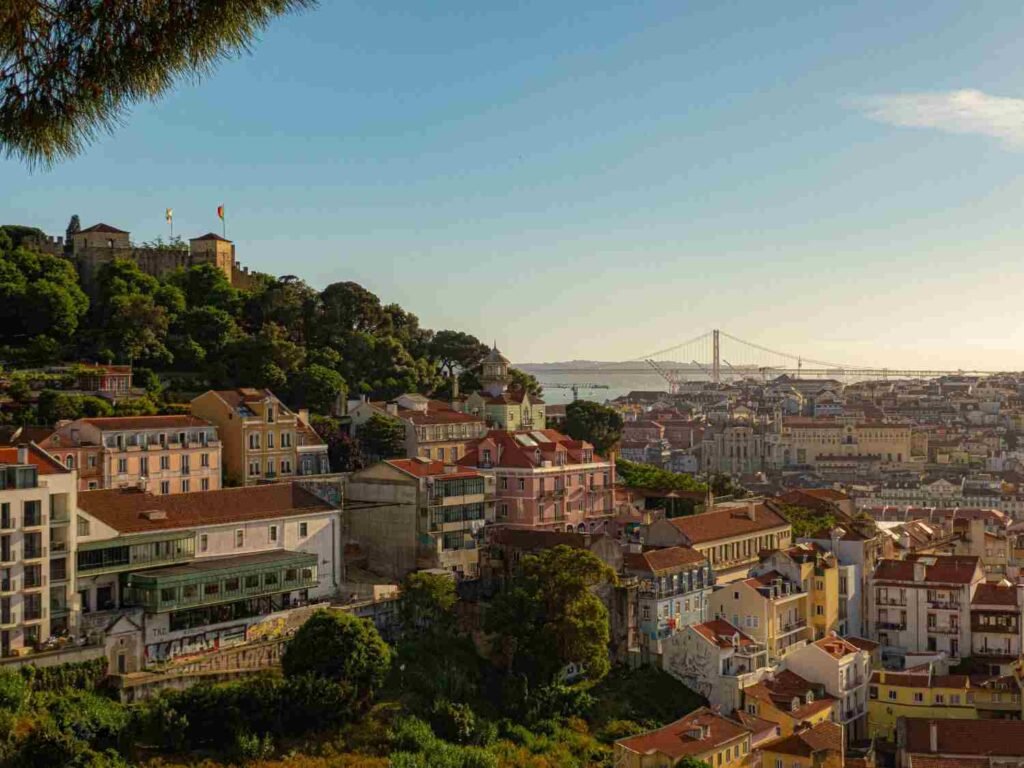 Lisbon Portugal historic cityscape with colorful buildings and the 25 de Abril Bridge