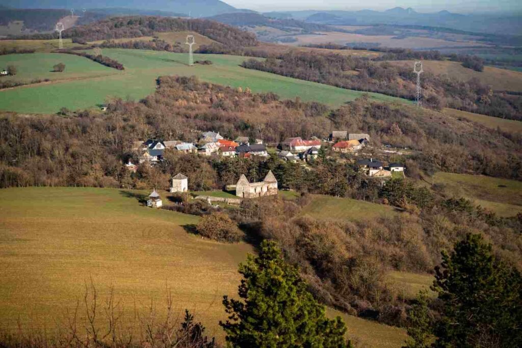 Aerial view of a small historic settlement and stone ruins amid rural countryside