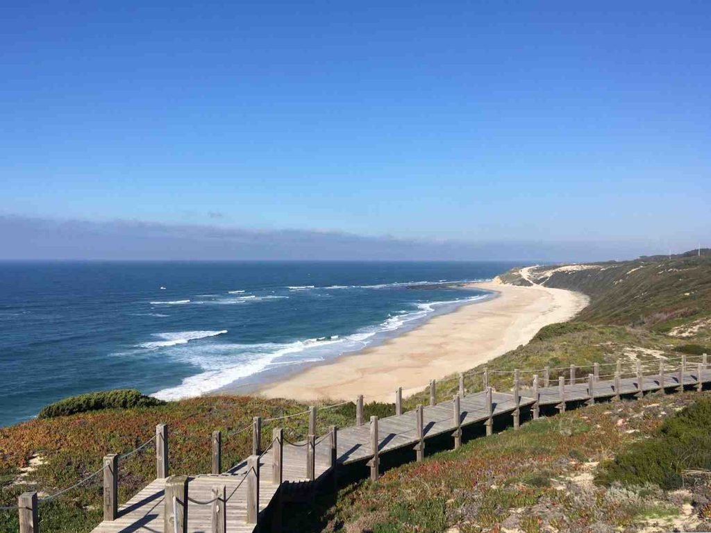 Praia da Arrifana beach with Atlantic waves and rugged cliffs in Portugal