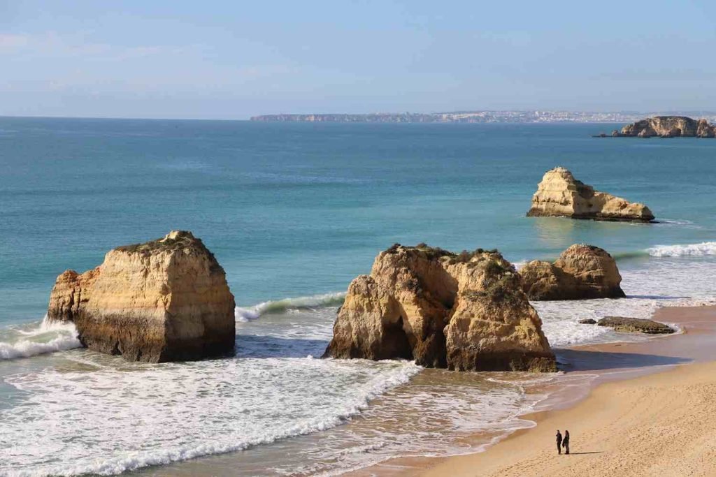 Turquoise water and golden limestone cliffs at Praia da Marinha, Portugal