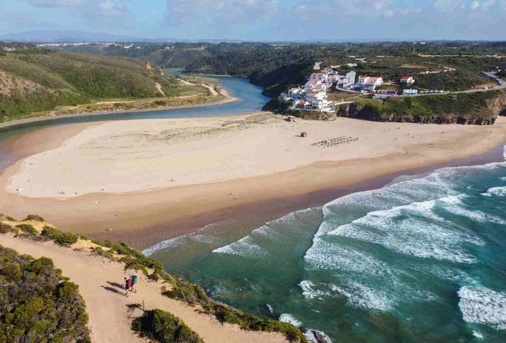 Sandy Praia de Odeceixe where the river meets the Atlantic Ocean in Portugal