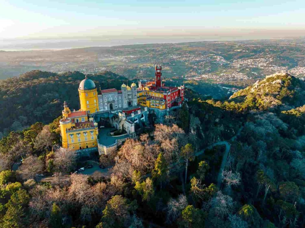 Colorful Pena Palace surrounded by forested hills in Sintra Portugal