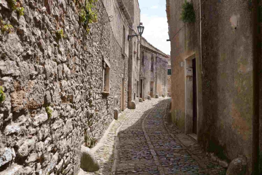 Narrow cobblestone street between old stone buildings in a historic Portuguese town