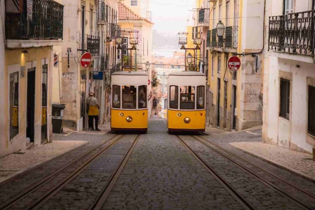 Yellow trams traveling along a historic street in Lisbon, Portugal.